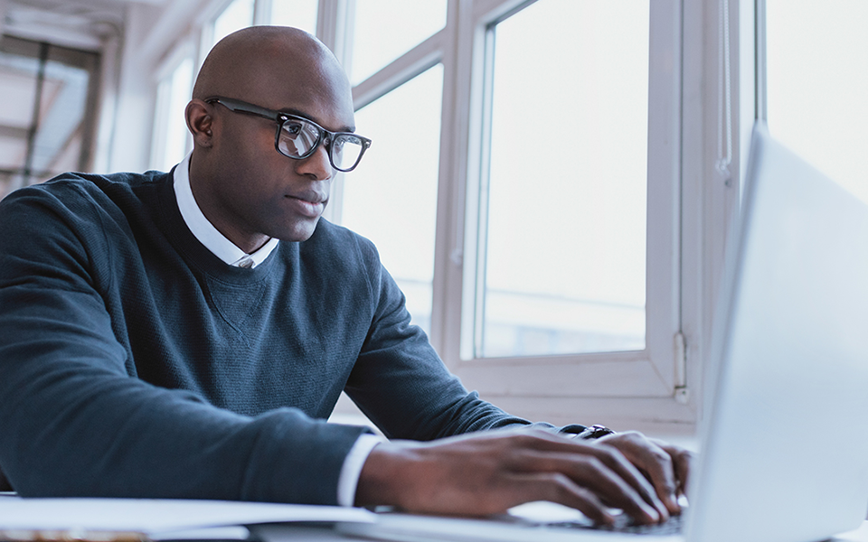 Man with glasses on his laptop