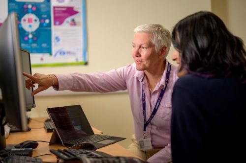 Two colleagues talking at desk