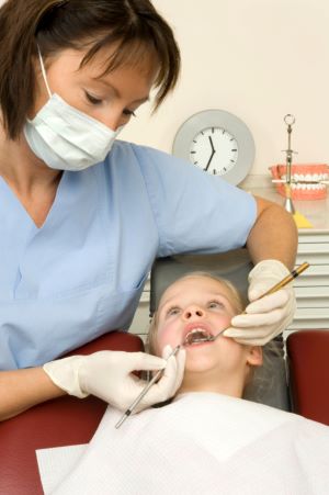 Dentist cleaning child's teeth