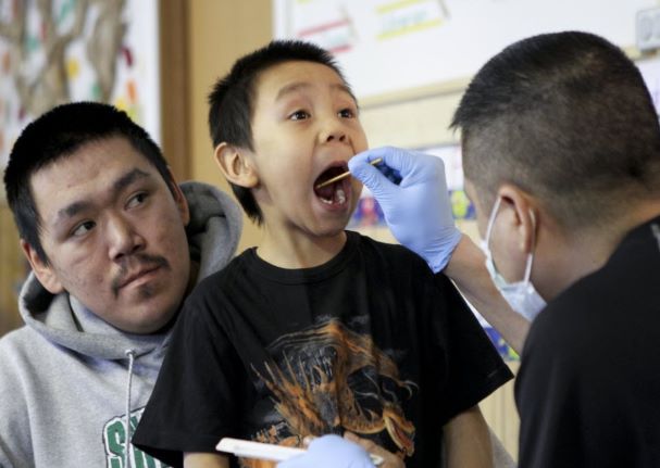 Alaska Native boy gets mouth swabbed