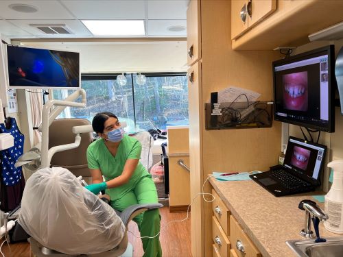 Dental hygienist takes pictures of child's teeth