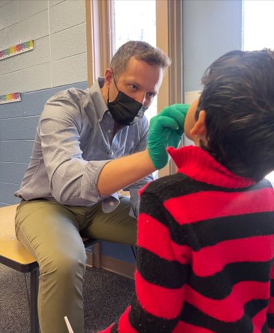 Ben Cozart, DDS, applies fluoride varnish to child's teeth