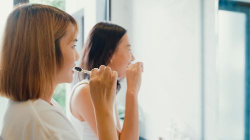 LGBTQ+ couple brushing teeth