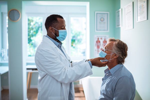 Man getting checked by doctor for dental pain.