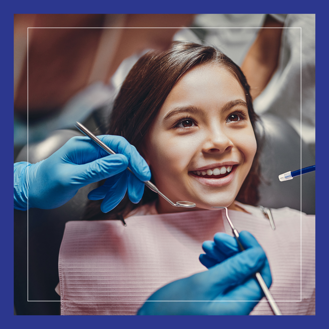 Young girl smiling, people holding dental instruments.