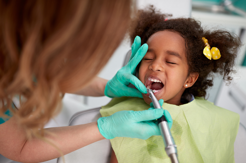 Dentist cleans child's teeth