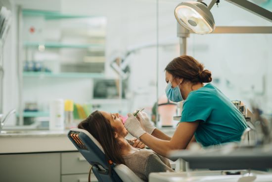 Dentist examines patient's teeth