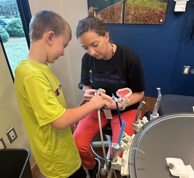 Jessica Ezzell, RDH, shows child how to properly brush teeth at school