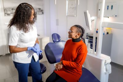 Dentist talks to patient sitting in chair