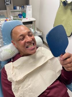 Veteran looks at teeth in dental chair