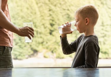 Child drinking water out of a glass