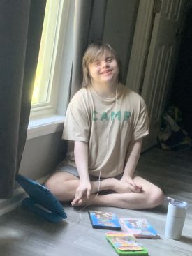 Joshua sitting on the floor at his house