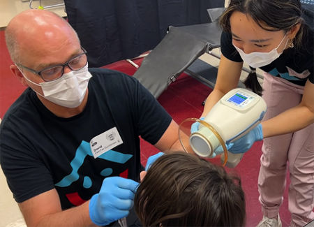 More Smiles Wisconsin dental team examines patient's teeth in chair