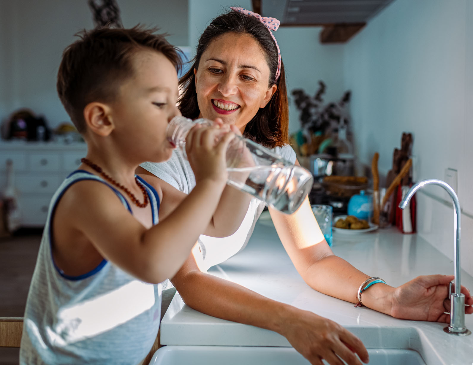 Mom with son drinking tap water with fluoride