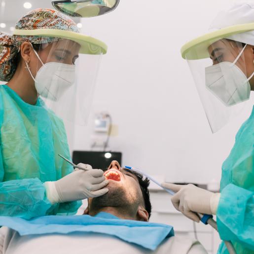 Female dental providers examining a male patient