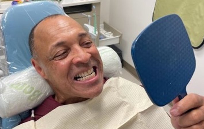 Veteran looking at his teeth in mirror