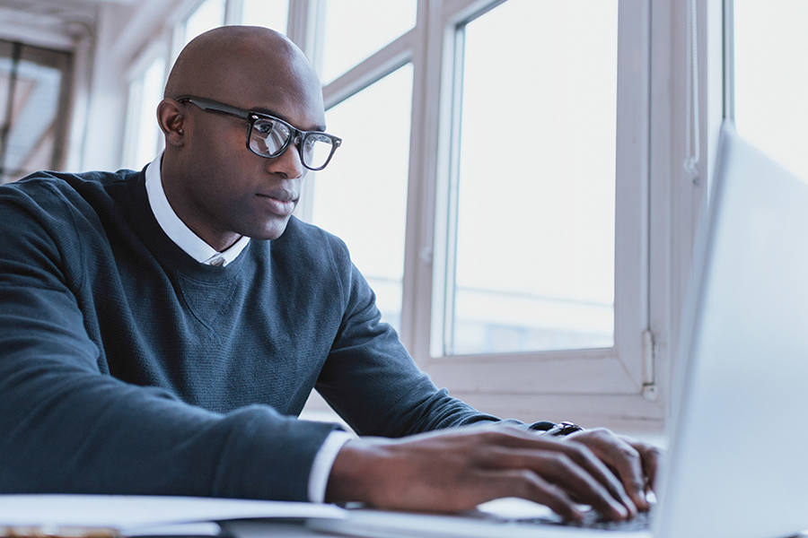 Man with glasses on his laptop