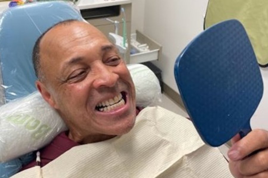 Veteran looking at his teeth in mirror